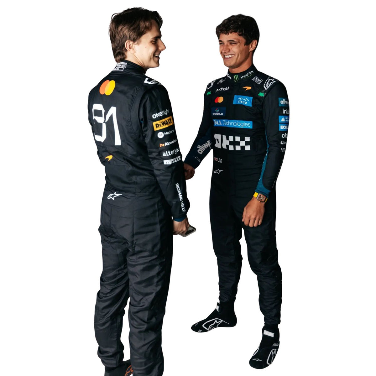 Lando Norris & Oscar Piastri in matching black Alpinestars team suits with sponsor logos, standing and smiling against a solid white background.
