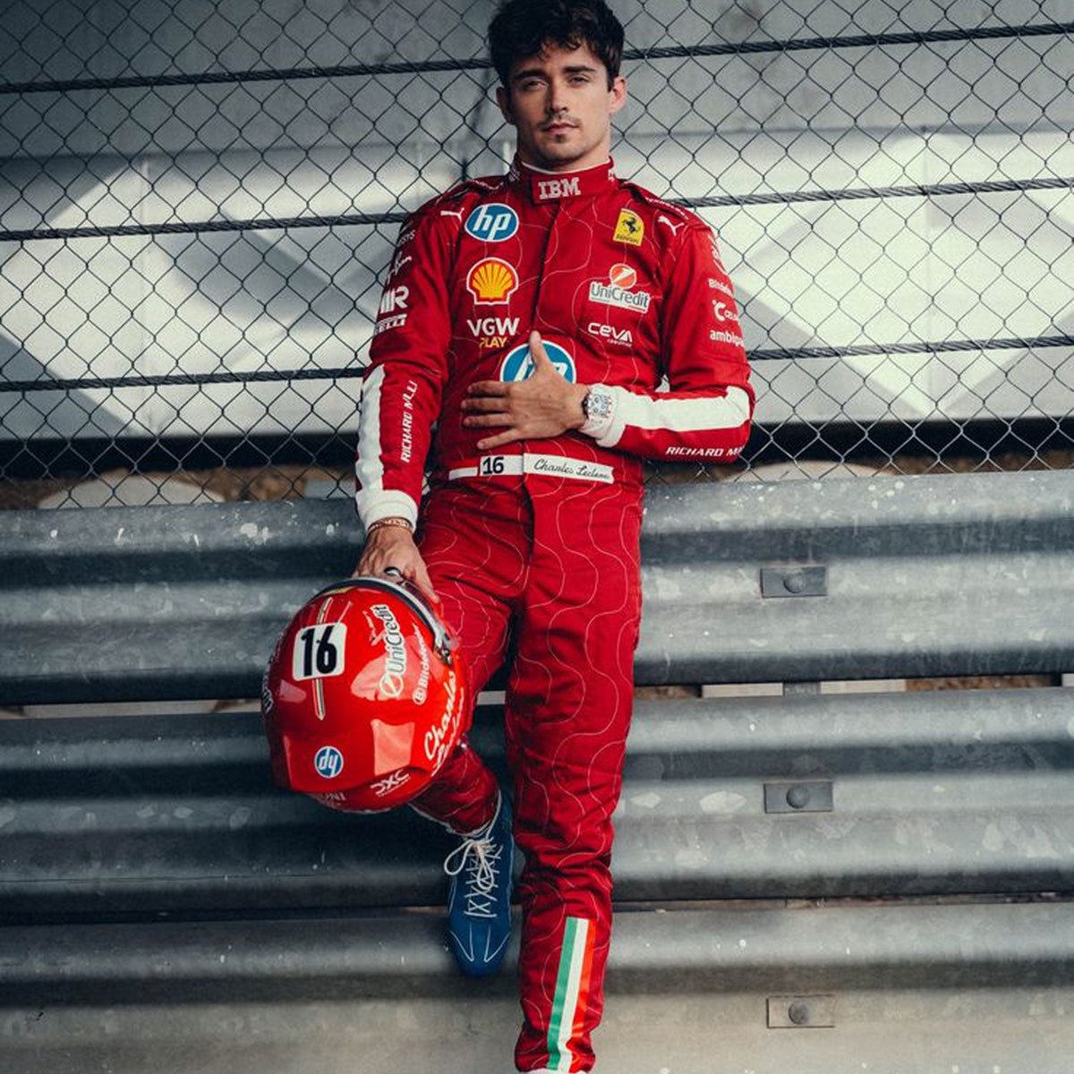Charles Leclerc 2025 F1 Race Costume Ferrari Monza GP holding a helmet with a fence in the background