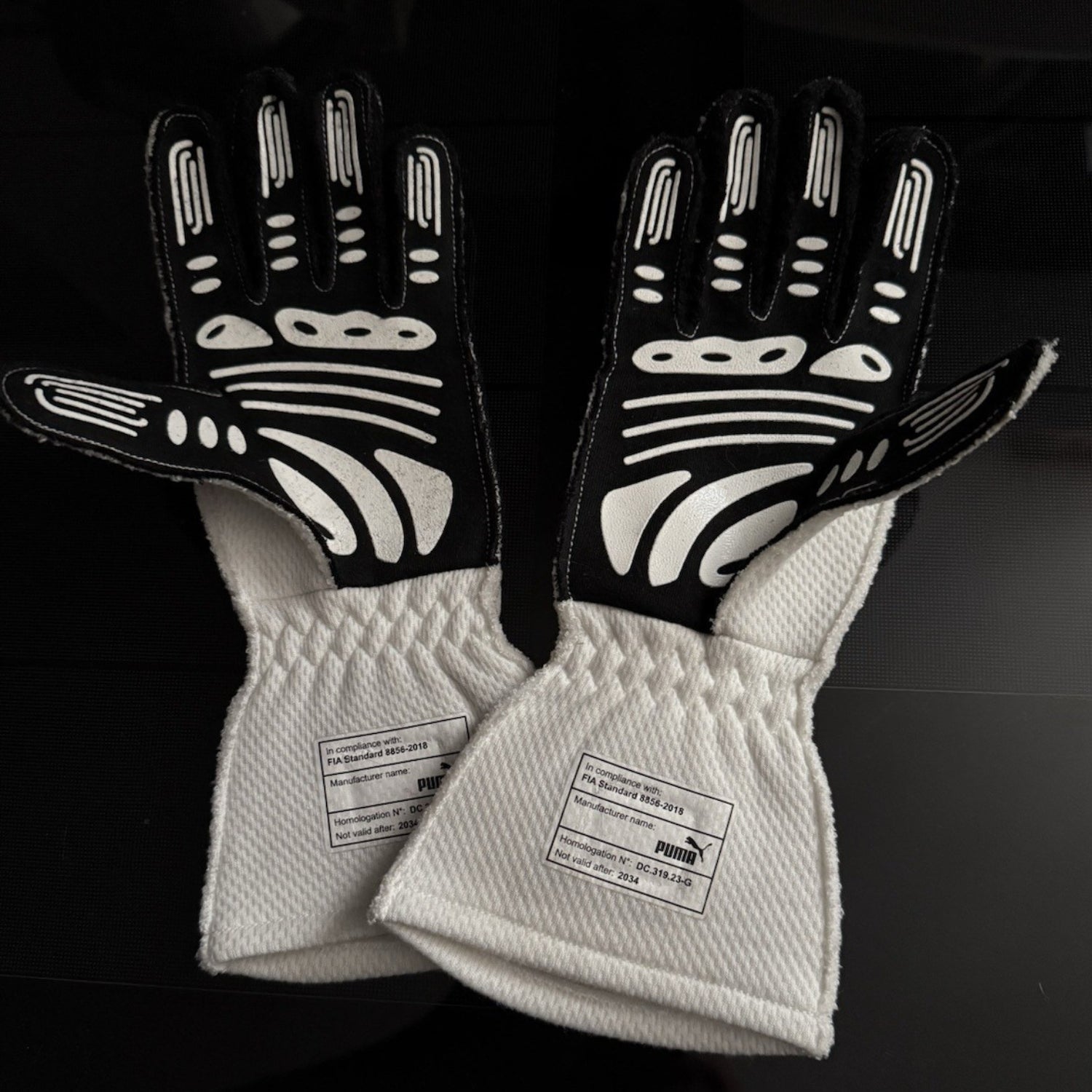 White George Russell 2024 Mercedes Qatar GP F1 Race Gloves shown side-on, highlighting the wrist strap and grip texture for grand prix use