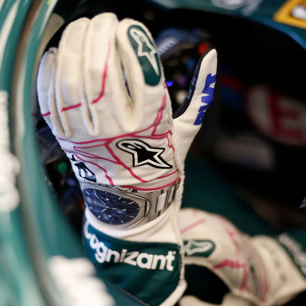 Close-up of a Lance Stroll 2021 Replica Race Gloves F1 Aston Martin with visible branding, worn by a driver in a car.