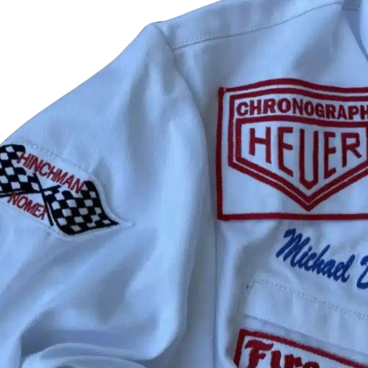 Close-up of a white Michael Delaney 1971 F1 The LeMans Movie Race Costume PorscheGulf (Steve McQueen) with embroidered logos and text.