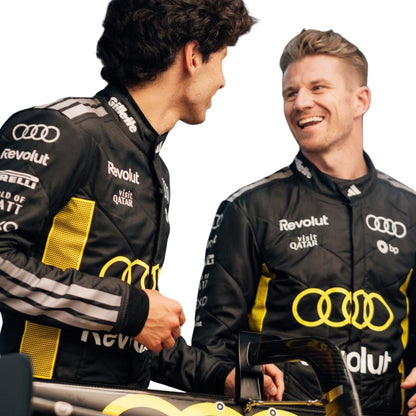Two men in Audi racing suits shaking hands with a car in the foreground.