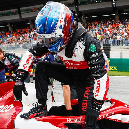 Formula 1 driver Valtteri Bottas in a pit stop with a red car and racing gear.